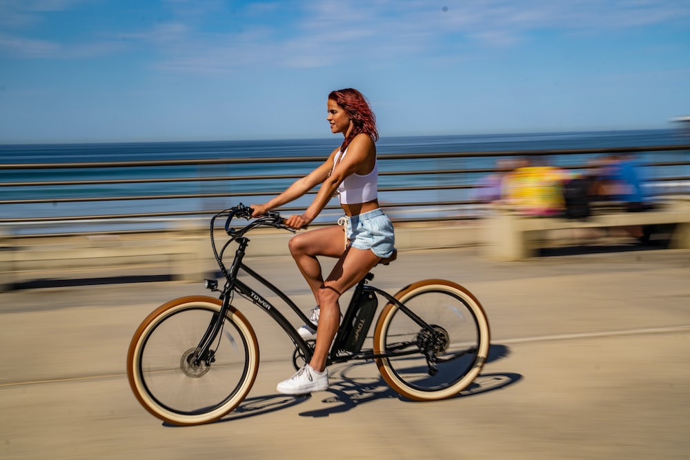 woman riding bike by beach